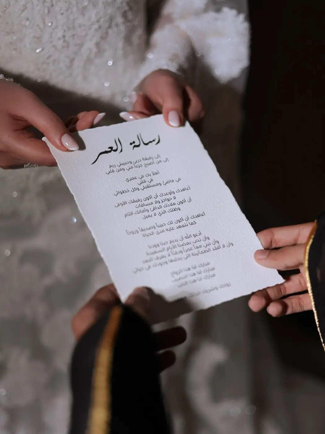 عروس تمسك بطاقة من تفاصيل الزفاف